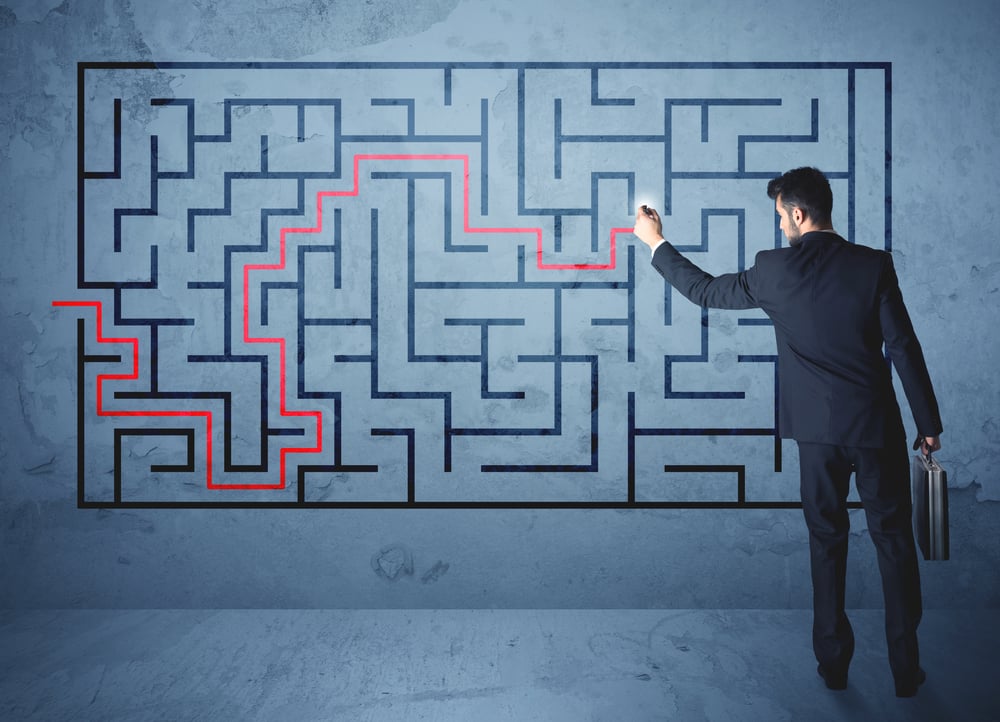 Businessman finding the solution of a maze